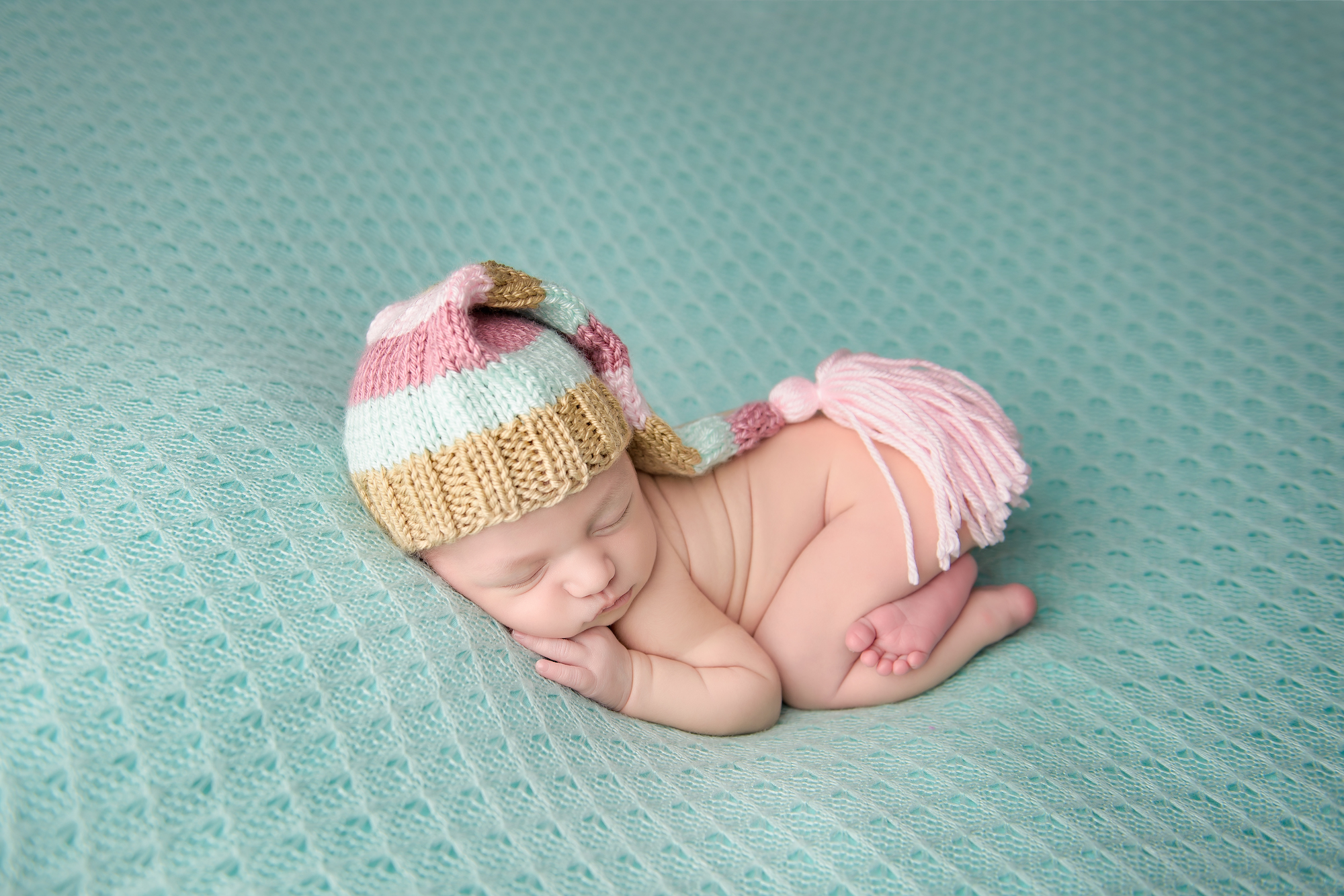 Calgary Newborn Photographer Baby Wearing Pink Hat On Mint Backdrop