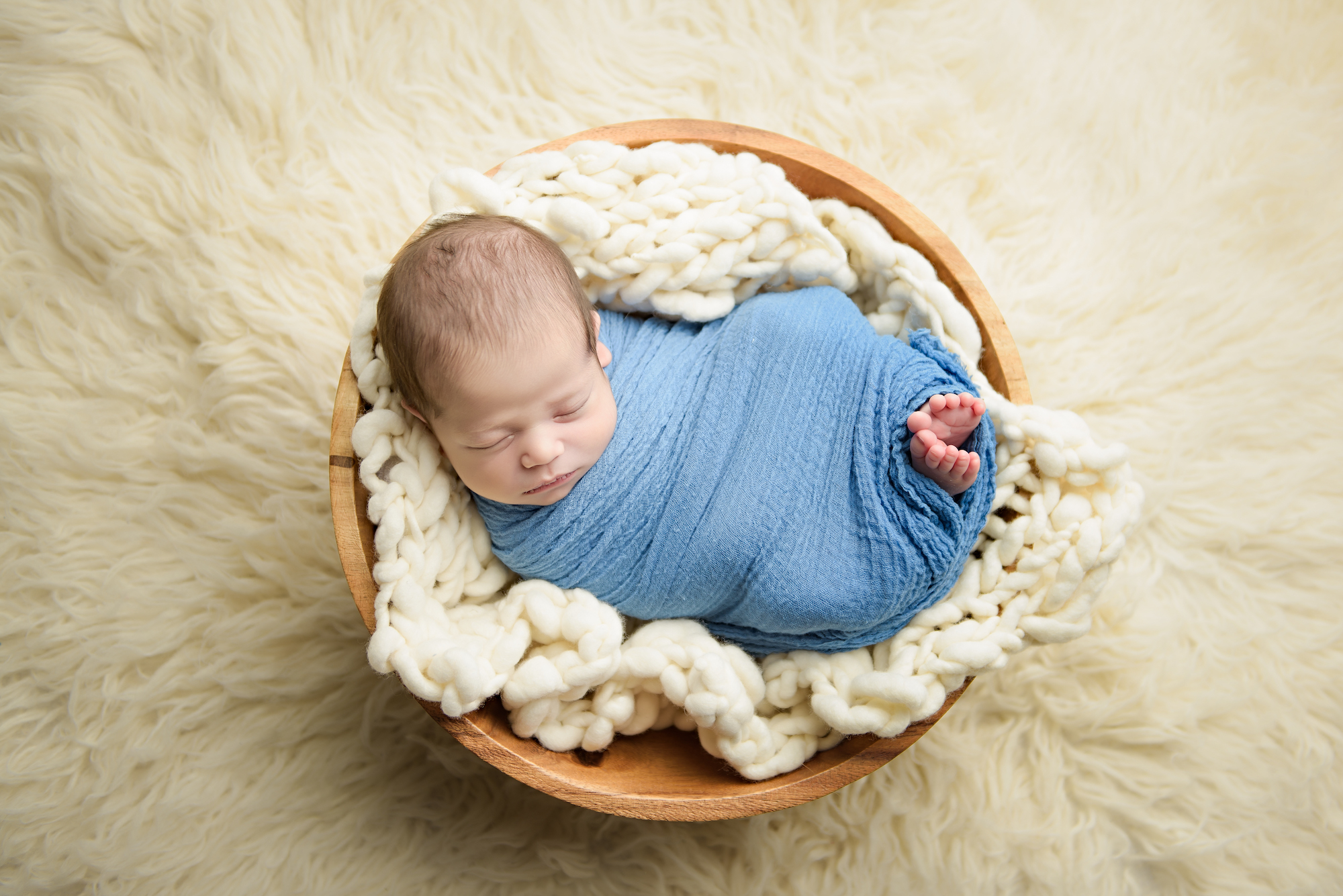Calgary Newborn Photographer Baby On Basket Cream Flokati