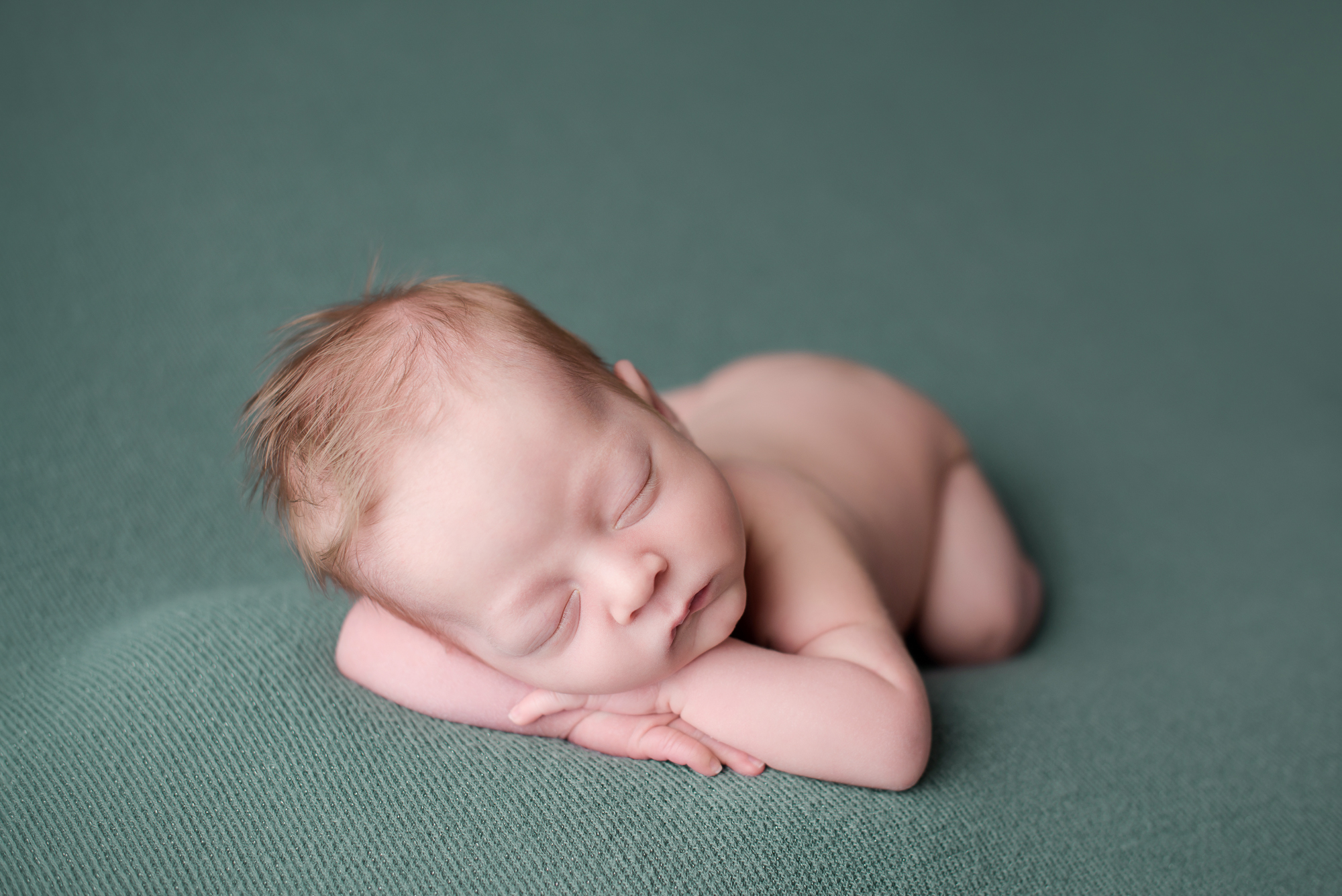 newborn photography baby boy on green blanket