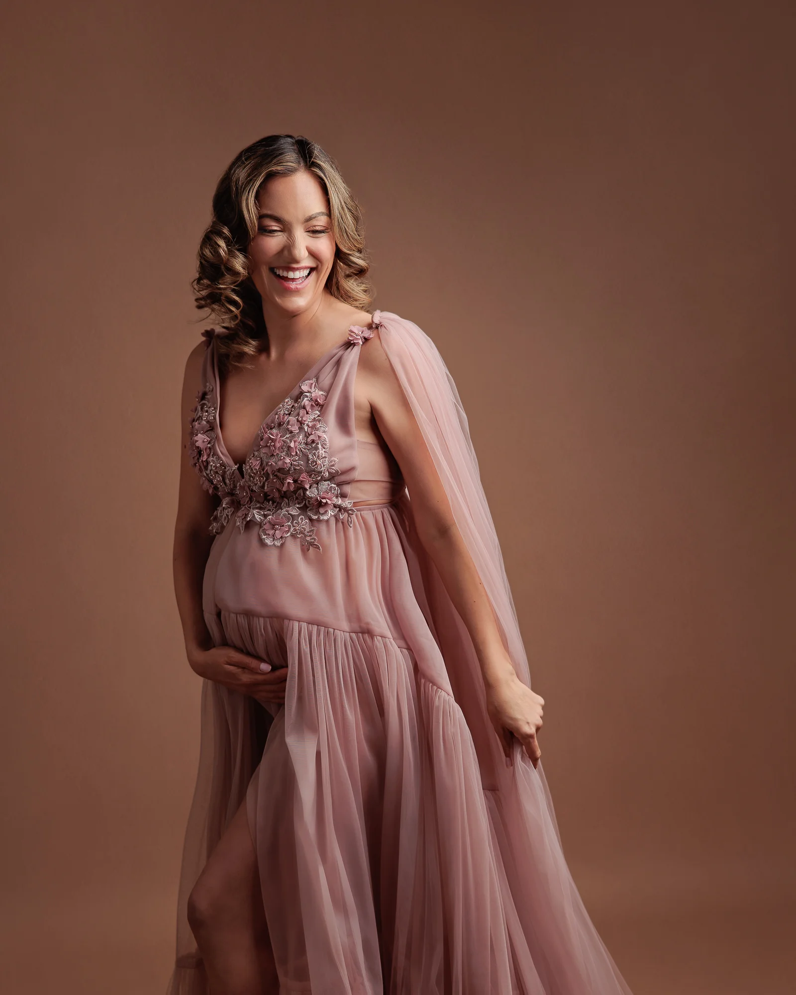 Pregnant woman laughing at her maternity photography