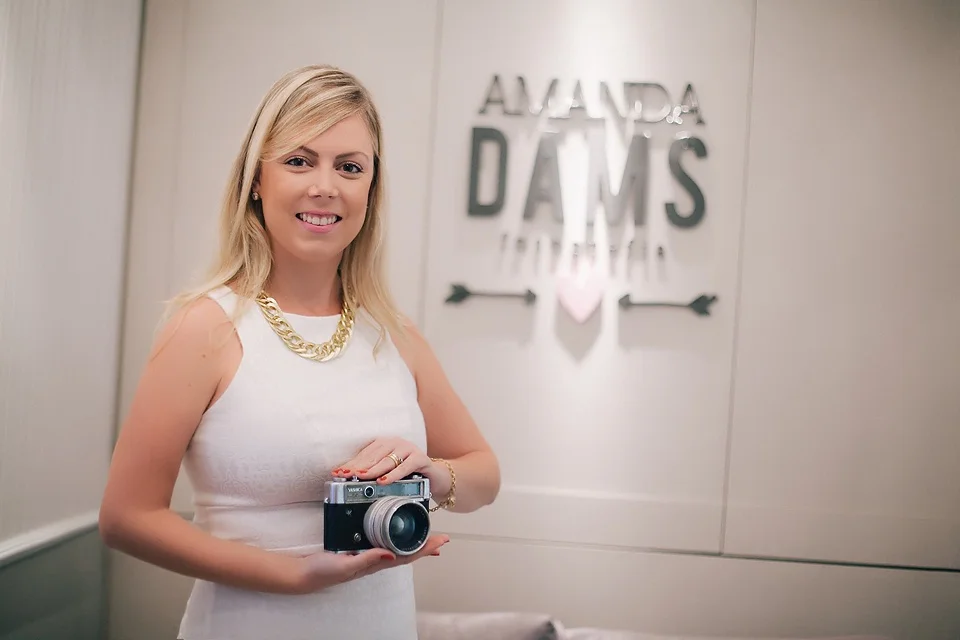 Amanda holding a camera at her newborn photography studio