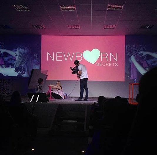Amanda on stage at Newborn Secrets Conference