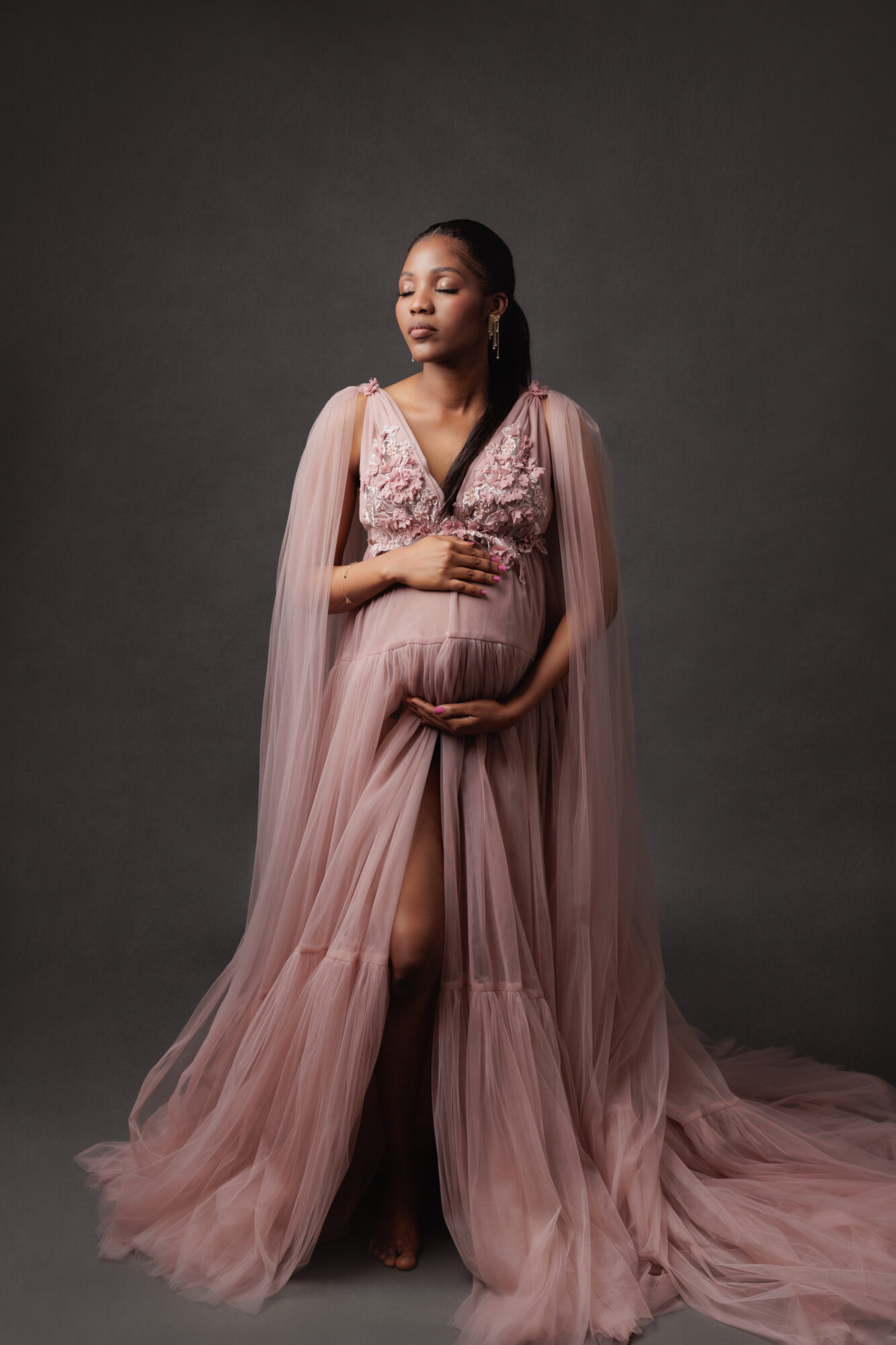 pregnant woman wearing a pink gown during a maternity photo in Calgary at Amanda Dams Photography Studio pregnant woman wearing a pink gown during a maternity photo in Calgary at Amanda Dams Photography Studio