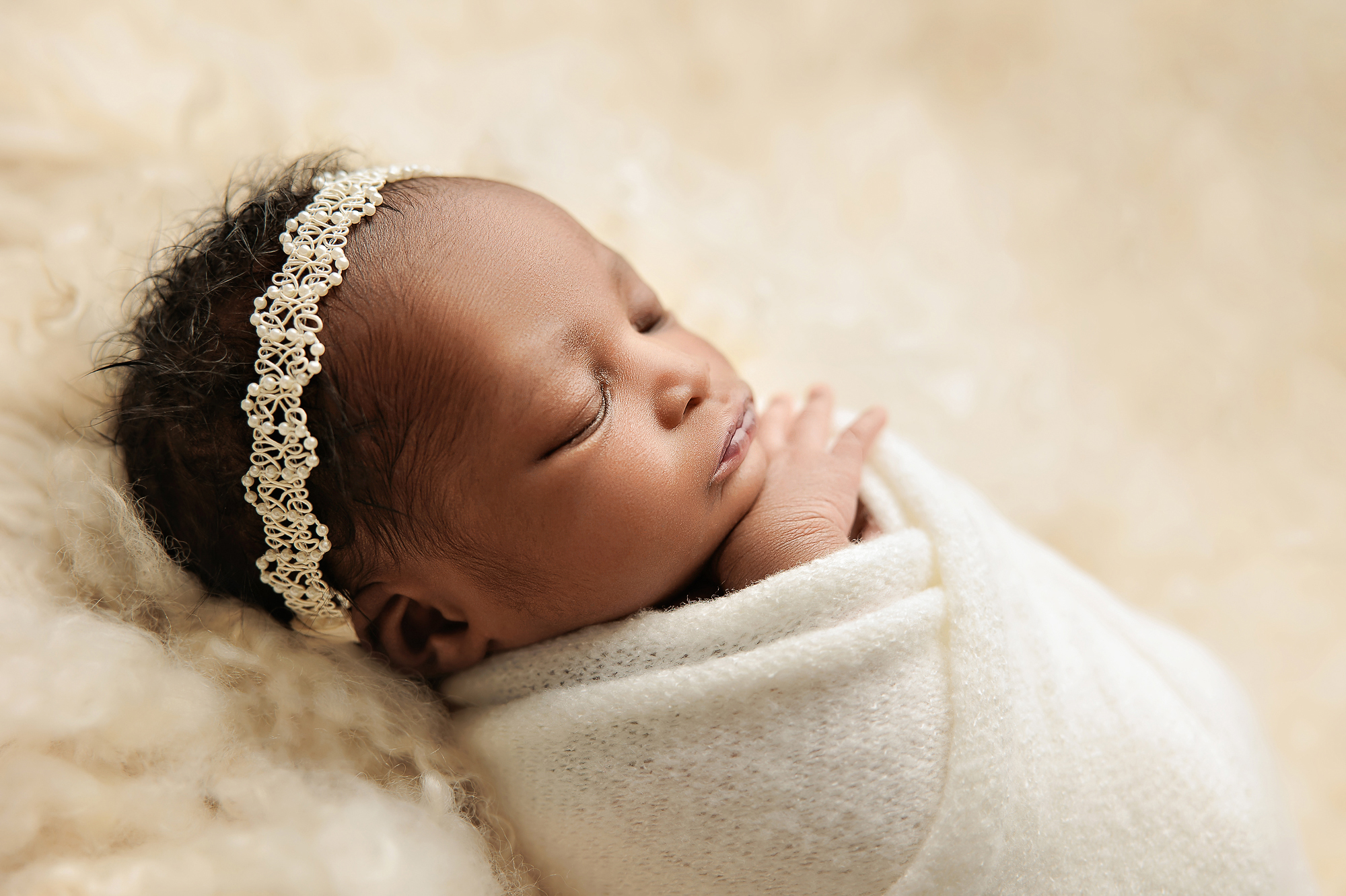 Family relaxing on a plush grey sofa during a newborn session