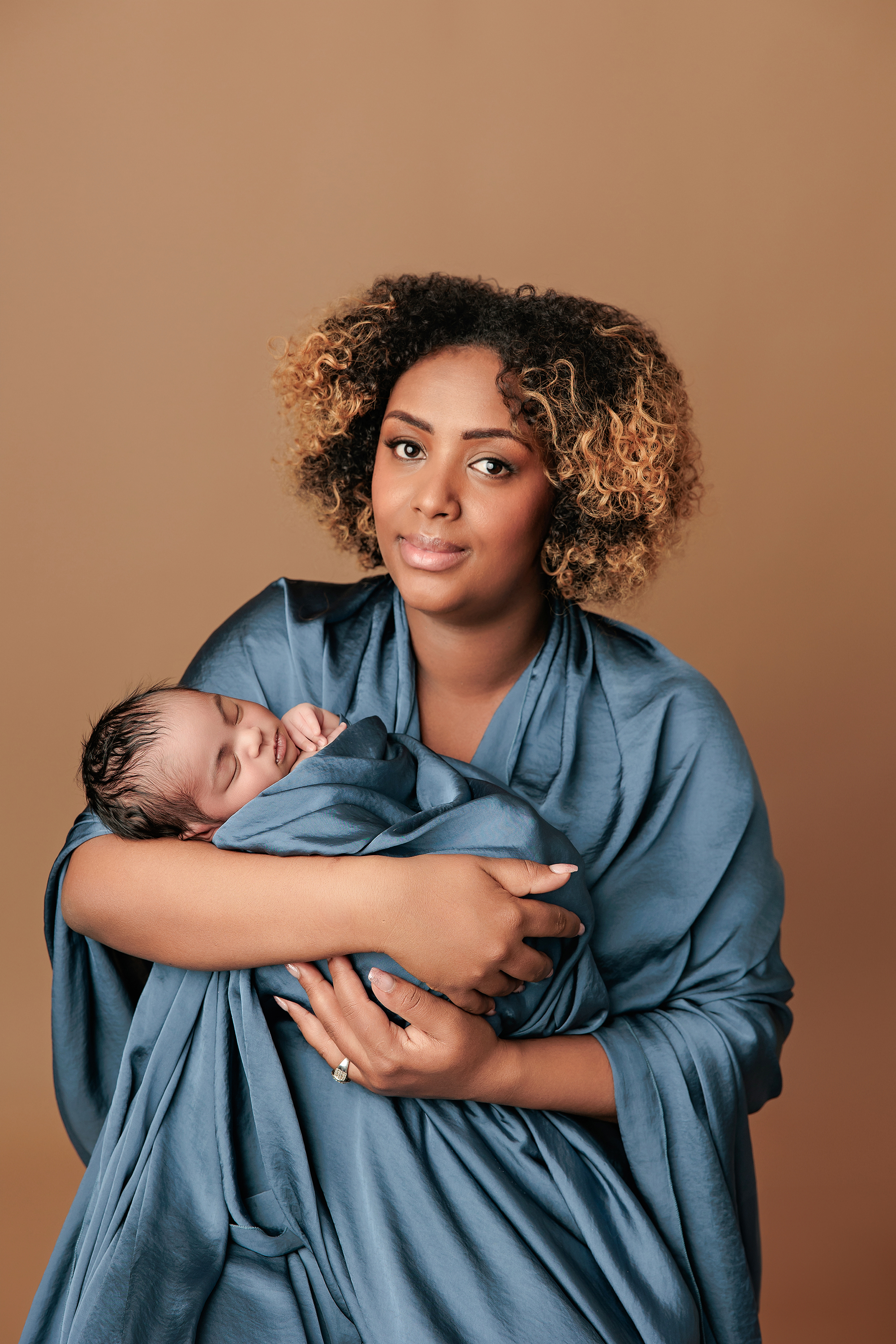 Premature baby in gentle wrap photographed after NICU stay in warm Calgary studio