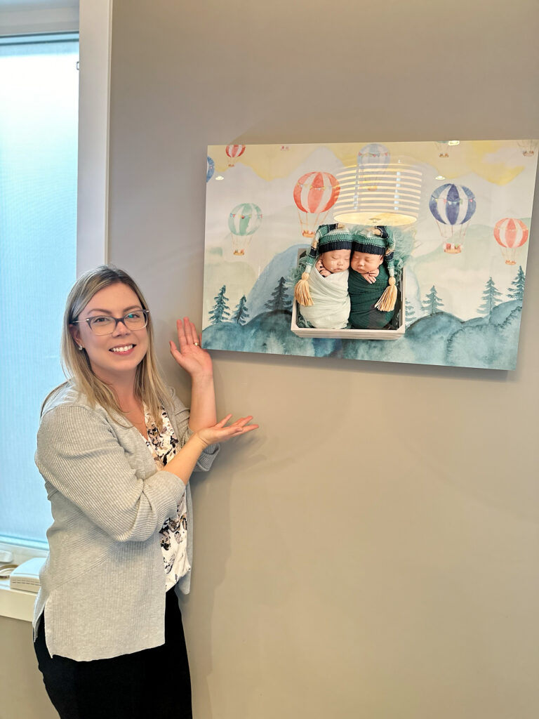 Amanda Dams showing an wall art of baby twins newborn session