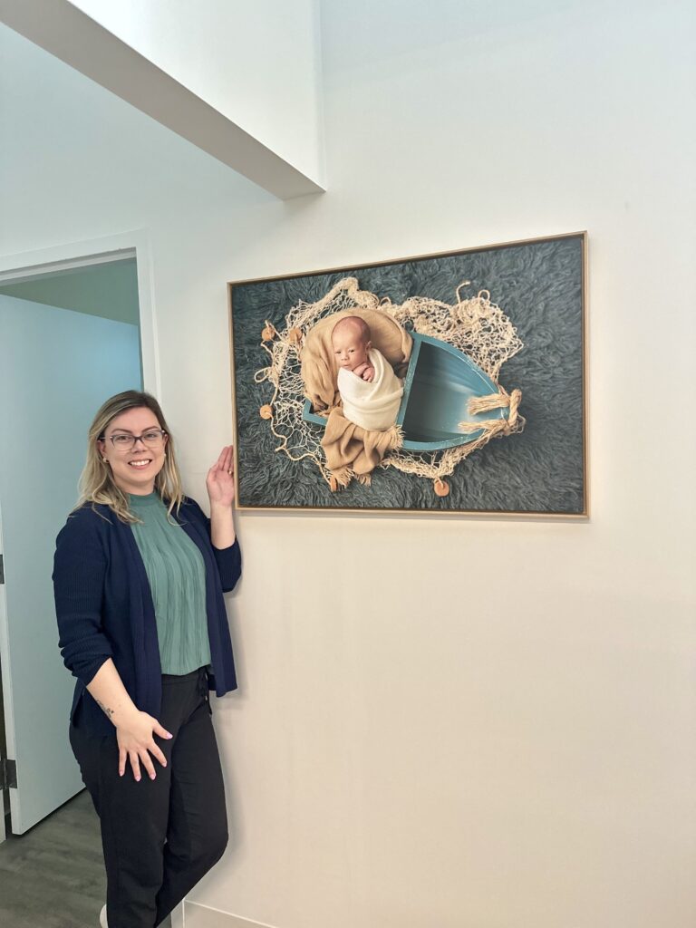 Amanda Dams showing a wall art from a newborn photo session in Calgary boat theme