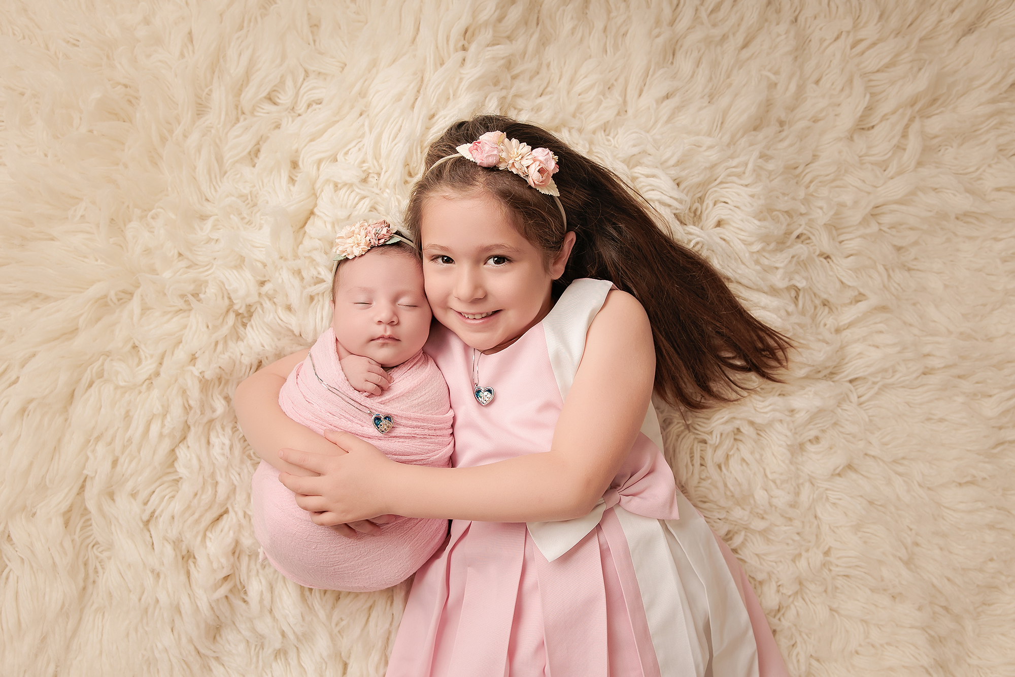big sister holding newborn baby during a calgary baby photoshoot